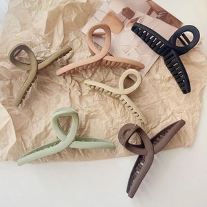 Gros plan de pinces à cheveux Morandi mates sur un fond de papier kraft texturé