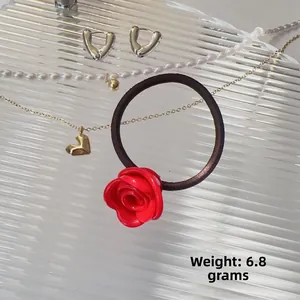 Détail d'un élastique à cheveux rose rouge en résine sur plateau en verre