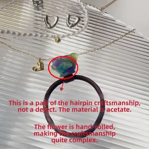 Détail de l'élastique à cheveux fait main avec fleur rose 3D en acétate violet et vert