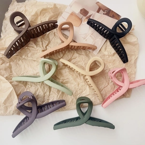 Lot de 8 pinces à cheveux mates de couleurs variées sur un fond de papier kraft esthétique