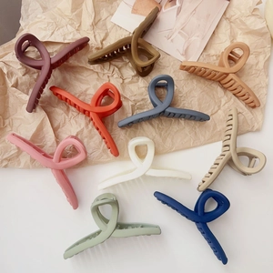 Neuf grandes pinces à cheveux mates aux couleurs Morandi sur papier à l'ombre douce