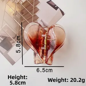 Macro di molletta a cuore ambrata con dimensioni 6,5 cm x 5,8 cm su uno sfondo bianco