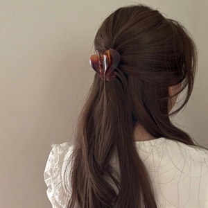 Elegante molletta per capelli a cuore sfumato color ambra su capelli castani