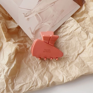 Detail of coral pink acetate hair claw clip with Barrette la France engraving and matte finish