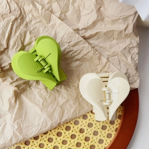 Dettaglio di fermagli per capelli opachi a forma di cuore, verde fluo e bianco crema