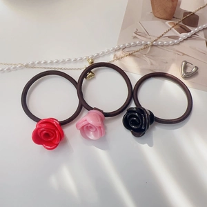 Vue détaillée d'élastiques à cheveux roses 3D en acétate en rouge, rose et noir