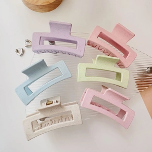 Set of 6 colorful square matte hair claw clips in macaron colors on a glass tray