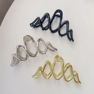Three elegant wavy metal shark hair clips in black, silver, and gold for versatile hairstyling