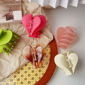 Vista dall'alto di cinque mollette per capelli a forma di cuore in vari colori moda