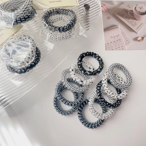 Detailed view of black and white spiral hair ties with checkerboard and dot patterns