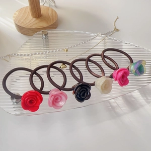 Lot de six chouchous à fleurs de rose en diverses couleurs sur un plateau clair