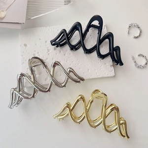 Three elegant hair claws in black, gold, and silver with a wavy geometric cutout design