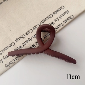Détail d'une pince à cheveux mate brun-rouge de 11cm avec un design anneau torsadé