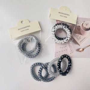 Detail of black and white phone cord hair ties with star and checkerboard patterns