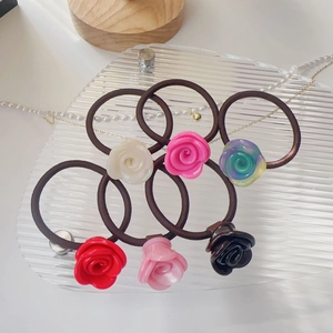 Détail de six chouchous à fleurs de rose en acétate colorés avec bandes élastiques