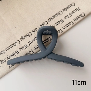 Détail de la pince à cheveux 11cm bleu-gris mat avec un design incurvé et croisé