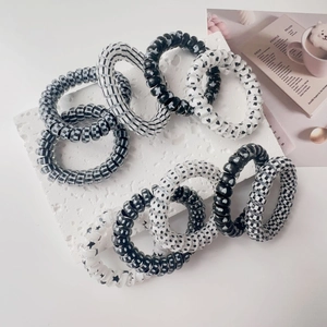 Close-up of black and white spiral hair ties with checkered and heart patterns