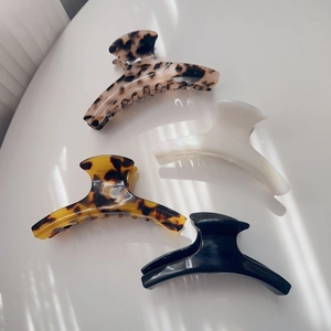 Detail showing four assorted acetate hair claws with gold handmade to France lettering