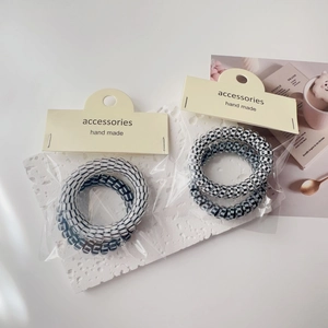 Close-up of checkerboard and striped spiral hair ties on minimalist card packaging