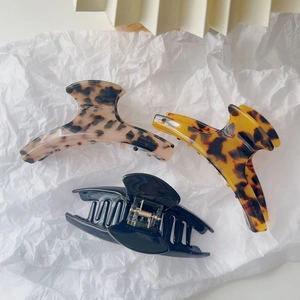 Detailed macro view of three acetate hair claw clips with handmade in France lettering