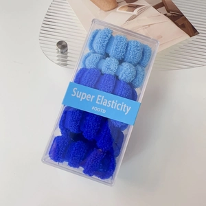 Detailansicht hoch elastischer Haargummis in Blau-Verlauf in einer klaren Geschenkbox