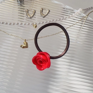 Gros plan détaillé d'un chouchou rose 3D en acétate rouge avec un élastique souple