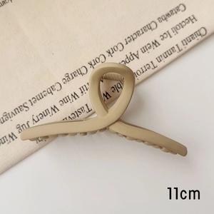 Détail de la pince à cheveux mate kaki de 11 cm avec design croisé et texture douce