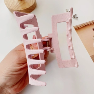 Detailed view of large matte light pink hair claw clip with unique speckled pattern