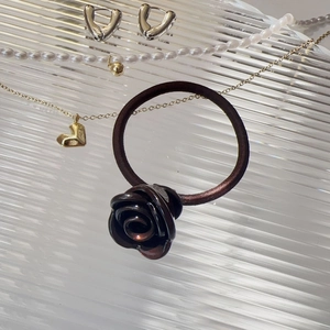 Vue détaillée d'un chouchou rose en résine marron foncé sur un plateau en verre décoratif