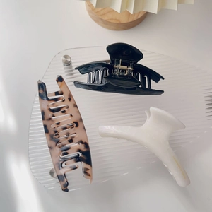 Detailed view of acetate hair claws in black, tortoiseshell and cream white colors