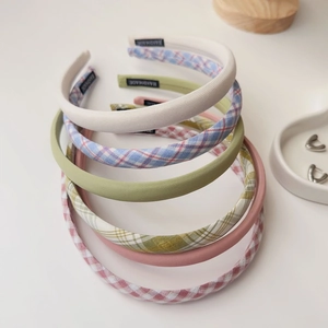 Detail of handmade fabric headbands in plaid and solid colors with HANDMADE labels