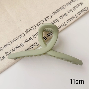 Détail de la pince à cheveux vert menthe mate de 11 cm avec design torsadé croisé