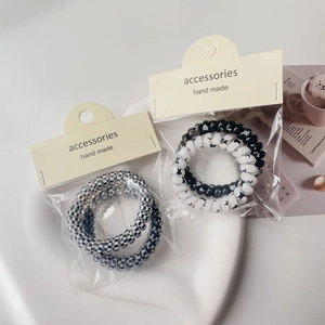 Detailed view of spiral telephone wire hair ties in checkerboard and star patterns