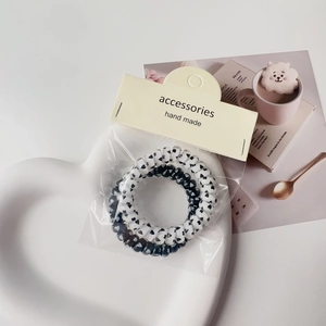 Detail of black and white heart pattern spiral hair ties on a white ceramic heart tray