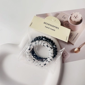 Detail of spiral hair ties in black and white star patterns on heart-shaped tray
