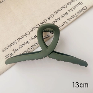 Vue détaillée d'une pince à cheveux mate vert foncé de 13 cm au design torsadé en résine