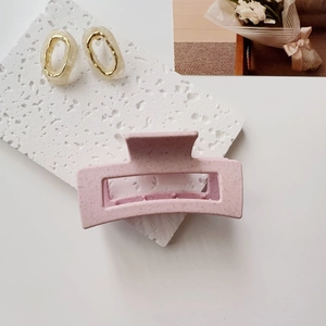 Detail view of matte pink sesame pattern hair claw clip with matching oval resin earrings