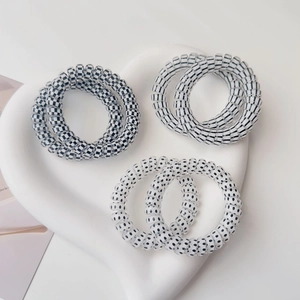 Spiral telephone cord hair ties in black and white patterns including polka dots and stripes