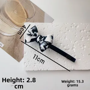 Detail of 11cm acetate bow hair clip with black and white marble pattern and dimensions