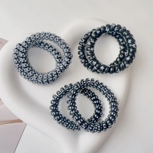 Detailed view of spiral telephone wire hair ties in checkered and star patterns