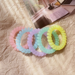 5-piece set of colorful matte spiral hair ties for women in pastel shades on textured paper