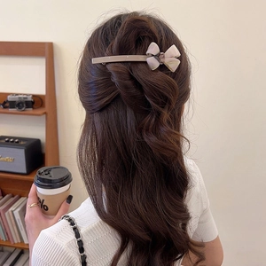 Close-up of elegant cream acetate bow spring clip worn in a vintage half-up hairstyle