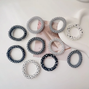 Set of 10 spiral hair ties in black, white, and grey patterns on a heart-shaped tray