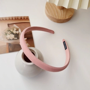 Detail of pink fabric headband with handmade tag in a minimalist home decor setting