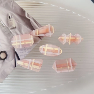 Lot de six barrettes à carreaux rose gelée sur un plateau en verre ondulé blanc