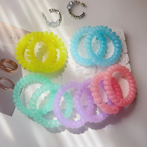 Detail of spiral telephone wire hair ties in pastel candy colors on a marble tray