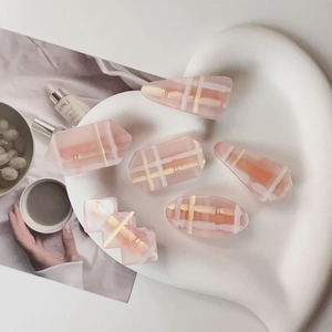 Détail d'un lot de 6 barrettes à cheveux rose à carreaux de formes variées sur plateau