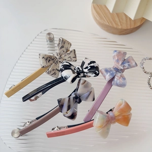 Detailed macro view of five vintage marble acetate bow clips with France Handmade text