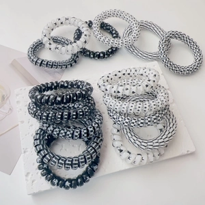 Detail of spiral telephone wire hair ties featuring black and white patterned designs