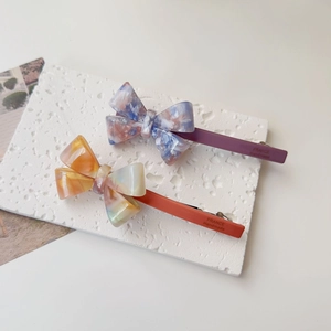 Close-up of marble pattern acetate bow clips with France Handmade text detail